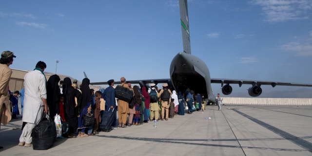 U.S. Air Force personnel assigned to the 816th Expeditionary Airlift Squadron load passengers aboard a C-17 Globemaster III in support of the Afghanistan evacuation at Hamid Karzai International Airport in Kabul, Afghanistan, on Aug. 24, 2021.