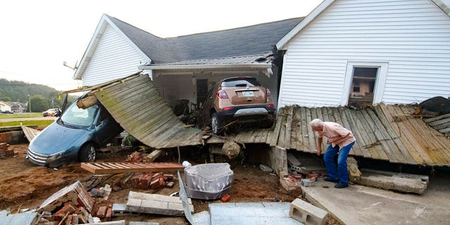 Ernest Hollis busca artículos en la casa de su nieta que fue devastada por las inundaciones el lunes 23 de agosto de 2021 en Waverly, Tennessee. 