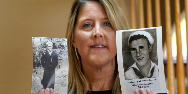 Teri Mann Whyatt displays photos of her uncle, William Edward Mann, who died on the USS Arizona during the bombing of Pearl Harbor, at her home Wednesday, July 14, 2021, in Newcastle, Wash. (AP Photo/Elaine Thompson)