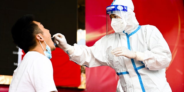 A medical worker collects a swab sample for nucleic acid test in Ruili City of southwest China's Yunnan Province on July 5, 2021. (Wang Guansen/Xinhua via AP, File)