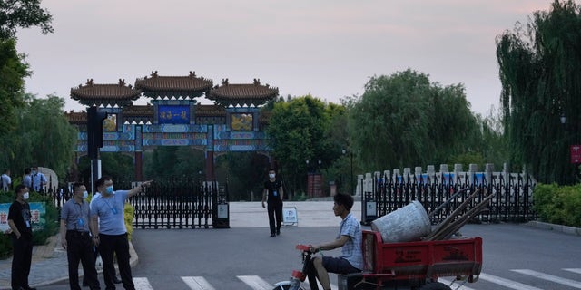 A worker carrying work tools walks past security personnel outside the Tianjin Binhai No.1 Hotel where U.S. and Chinese officials are expected to hold talks in Tianjin Municipality in China on Sunday, July 25, 2021. Assistant Secretary of State Wendy Sherman visited China this weekend on a visit that comes as tensions between Washington and Beijing soar on several fronts, the State Department said on Wednesday.
