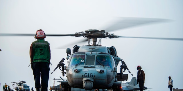 In this photo provided by the U.S. Navy, sailors on board an MH-60S Seahawk helicopter on the flight deck of aircraft carrier USS Ronald Reagan prepare to head to an oil tanker that was attacked off the coast of Oman in the Arabian Sea on Friday, July 30, 2021. An attack on an oil tanker linked to an Israeli billionaire killed two crew members off Oman in the Arabian Sea, authorities said Friday, marking the first fatalities after years of assaults targeting shipping in the region. (Mass Communication Specialist 2nd Class Quinton A. Lee/U.S. Navy, via AP)