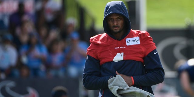 Texans quarterback Deshaun Watson (4) wipes his hands after stretching during NFL football practice Saturday, July 31, 2021, in Houston. (AP Photo/Justin Rex)