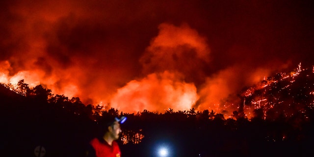 A man leaves as fires rage in the Hisaronu region of Turkey on Monday, August 2, 2021. For the sixth day in a row, Turkish firefighters battled on Monday to control the fires that are ravaging forests near seaside destinations in Turkey.