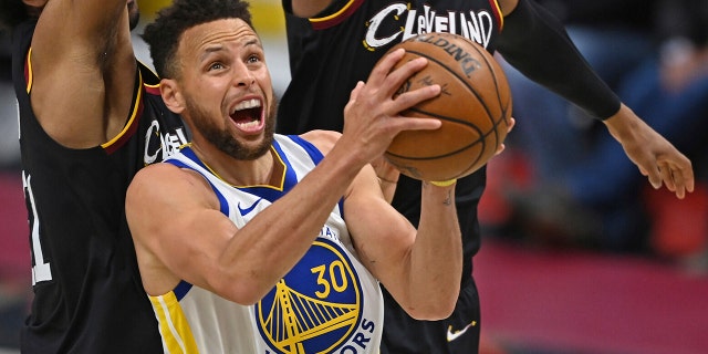 In this April 15, 2021, file photo, Golden State Warriors' Stephen Curry goes to the basket against Cleveland Cavaliers' Jarrett Allen (31) and Isaac Okoro during the second half of an NBA basketball game in Cleveland.