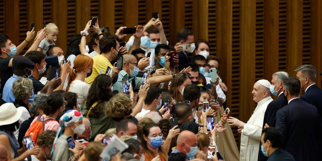 Pope Francis greets the faithful at the end of his weekly general audience in the Paul VI hall at the Vatican, Wednesday, Aug. 4, 2021. Pope Francis on Wednesday resumed his routine of weekly audiences with the general public a month after he underwent bowel surgery, expressing his desire to visit someday Lebanon, as he recalled the first anniversary of the devastating Beirut port explosion. (AP Photo/Riccardo De Luca)