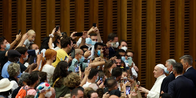 Pope Francis greets the faithful at the end of his weekly general audience in the Paul VI hall at the Vatican, Wednesday, Aug. 4, 2021. Pope Francis on Wednesday resumed his routine of weekly audiences with the general public a month after he underwent bowel surgery, expressing his desire to visit someday Lebanon, as he recalled the first anniversary of the devastating Beirut port explosion. (AP Photo/Riccardo De Luca)