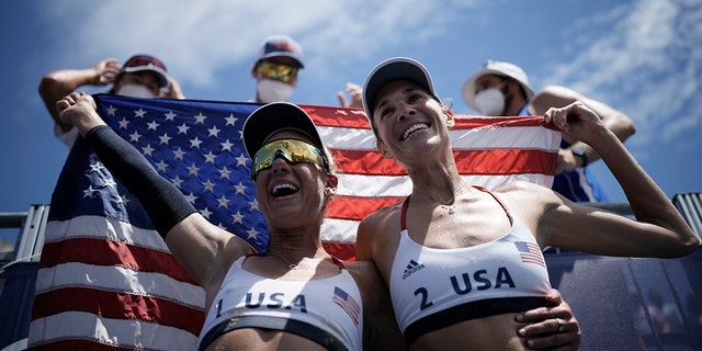 April Ross, left, of the United States, and teammate Alix Klineman celebrate winning a women's beach volleyball Gold Medal match against Australia at the 2020 Summer Olympics, Friday, Aug. 6, 2021, in Tokyo, Japan. (Associated Press)