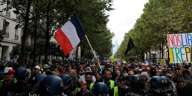 Des manifestants anti-vaccins affrontent la police lors d'une manifestation contre les vaccins et les passeports vaccinaux, à Paris, en France, le samedi 7 août 2021.