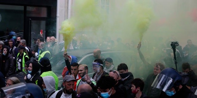 Un manifestante contra la vacunación sostiene una antorcha durante una protesta contra las vacunas y los pasaportes de vacunas, en París, Francia, el sábado 7 de agosto de 2021.