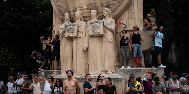 Los manifestantes cantan cánticos durante una manifestación en Marsella, sur de Francia, el sábado 7 de agosto de 2021.