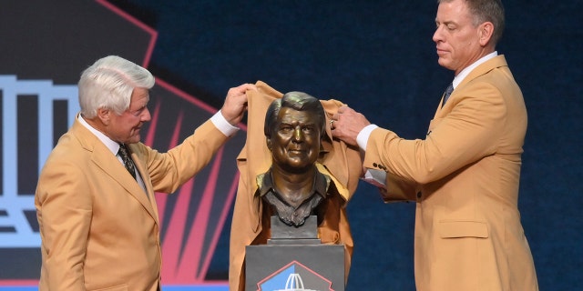 Jimmy Johnson, left, a member of the Pro Football Hall of Fame Centennial Class, shows off his bust with presenter Troy Aikman during the Pro Football Hall of Fame induction ceremony on Saturday August 7, 2021 in Canton, Ohio.  (Associated press)