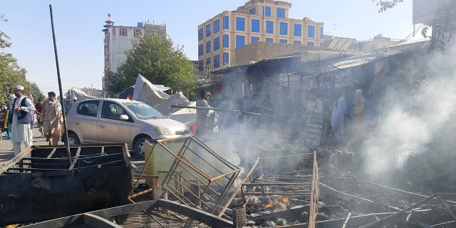 Smoke rises from damaged stores after fighting between the Taliban and Afghan security forces in the northern Afghan town of Kunduz on Sunday, August 8, 2021 (AP Photo / Abdullah Sahil)