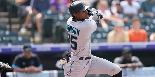 Miami Marlins' Lewis Brinson follows the flight of his double that drove in two runs off Colorado Rockies starting pitcher Kyle Freeland in the fifth inning of a baseball game Sunday, Aug. 8, 2021, in Denver. (AP Photo/David Zalubowski)