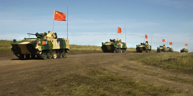 FILE - In this Aug. 13, 2007, file photo, a convoy of Chinese APCs roll by during a rehearsal for a massive joint military exercise by the two former Cold War rivals, the first on Russia's territory in the Chelyabinsk region in Russia's Ural Mountains.