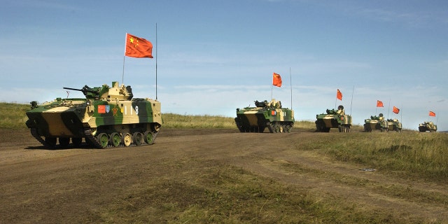 FILE - In this Aug. 13, 2007, file photo, a convoy of Chinese APCs roll by during a rehearsal for a massive joint military exercise by the two former Cold War rivals, the first on Russia's territory in the Chelyabinsk region in Russia's Ural Mountains.