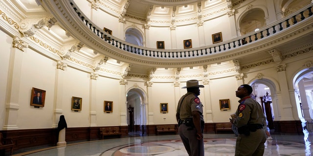 Texas Department of Safety officers stand watch over the Texas Capitol, Wednesday, Aug. 11, 2021, in Austin, Texas. Officers of the Texas House of Representatives delivered civil arrest warrants for more than 50 absent Democrats on Wednesday as frustrated Republicans ratcheted up efforts to end a standoff over a sweeping elections bill that stretched into its 31st day. (AP Photo/Eric Gay)