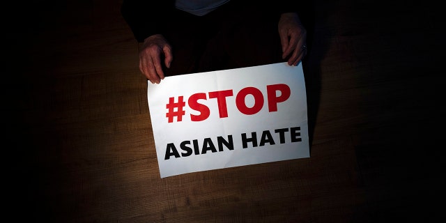 FILE - In this March 31, 2021, file photo, Jen Ho Lee, a 76-year-old South Korean immigrant, poses in her apartment in Los Angeles with a sign from a recent rally against anti-Asian hate crimes she attended. A new report released Thursday Aug. 12 has found the frequency of anti-Asian incidents, from taunts to outright assaults, reported in the United States so far this year seems poised to surpass last year despite months of political and social activism.