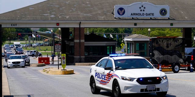 A Metropolitan Police Department cruiser drives out of an entrance to Joint Base Anacostia-Bolling during a lockdown, Friday, Aug. 13, 2021, in Washington. The base was placed on lockdown after a report that an armed person was spotted on the base. (AP Photo/Patrick Semansky)