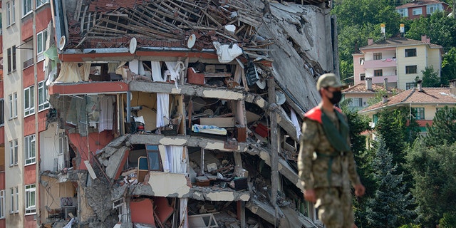 A soldier walks on a temporary bridge set up by military in Bozkurt town of Kastamonu province, Turkey, Sunday, Aug. 15, 2021, after flooding. Turkey sent ships to help evacuate people and vehicles from a northern town on the Black Sea that was hard hit by flooding, as the death toll in the disaster rose Sunday to at least 62 and more people than that remained missing.