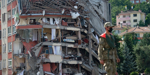 A soldier walks on a temporary bridge set up by military in Bozkurt town of Kastamonu province, Turkey, Sunday, Aug. 15, 2021, after flooding. Turkey sent ships to help evacuate people and vehicles from a northern town on the Black Sea that was hard hit by flooding, as the death toll in the disaster rose Sunday to at least 62 and more people than that remained missing.