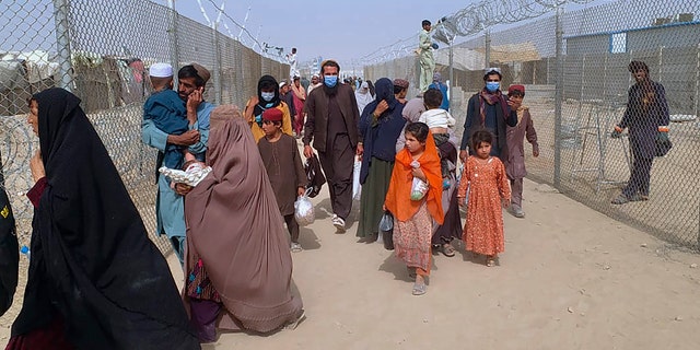 Les voyageurs entrent au Pakistan par un point de passage frontalier à Chaman, au Pakistan, le lundi 16 août 2021. Un vol spécial de la compagnie aérienne nationale pakistanaise PIA est arrivé à Islamabad transportant 329 passagers en provenance de Kaboul, et un autre transportant 170 personnes arrivera plus tard dans la journée. Un porte-parole de la compagnie aérienne a déclaré samedi que la compagnie aérienne opérerait trois vols demain pour transporter des Pakistanais et d'autres nationalités souhaitant quitter Kaboul. (Photo AP/Jafar Khan)