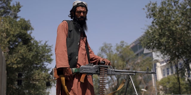 Un combattant taliban monte la garde à la porte principale menant au palais présidentiel afghan, à Kaboul, en Afghanistan, le lundi 16 août 2021. L'armée américaine a eu du mal à gérer une évacuation chaotique d'Afghanistan lundi alors que les talibans patrouillaient dans la capitale et tentaient pour projeter le calme après avoir renversé le gouvernement soutenu par l'Occident. (Photo AP/Rahmat Gul)