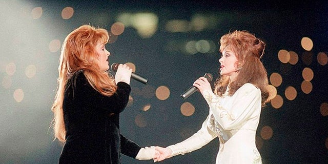 FILE - Wynonna Judd, left, and her mother Naomi Judd, of The Judds, perform during the halftime show at Super Bowl XXVIII in Atlanta on Jan. 30, 1994. The Grammy-winning duo will be inducted into the Country Music Hall of Fame.  (AP Photo/Eric Draper, File)