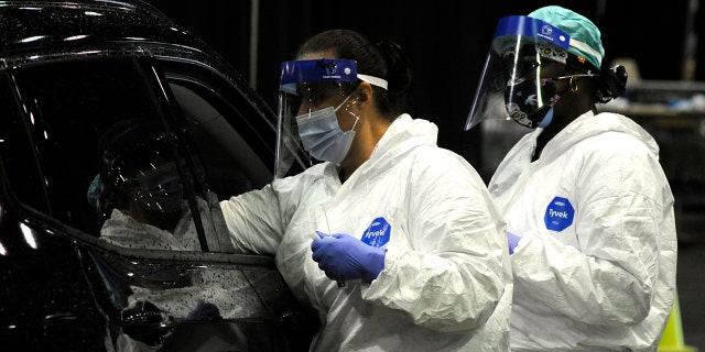 Workers from USA Health test a person for COVID-19 during a drive-up clinic in Mobile, Alabama, Aug. 12, 2021. (Associated Press)