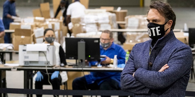 In this Nov. 25, 2020, photo, Fulton County Georgia election chief Rick Barron talks to reporters as workers scan ballots during a presidential recount in Atlanta.