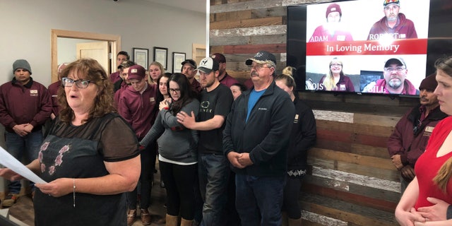 In this Friday, April 5, 2019, file photo, Jackie Fakler, co-owner of RJR Maintenance and Management, is surrounded by employees, in Mandan, North Dakota, as she reads a statement about the slayings of four RJR employees earlier in the week. (AP Photo/James MacPherson, File)