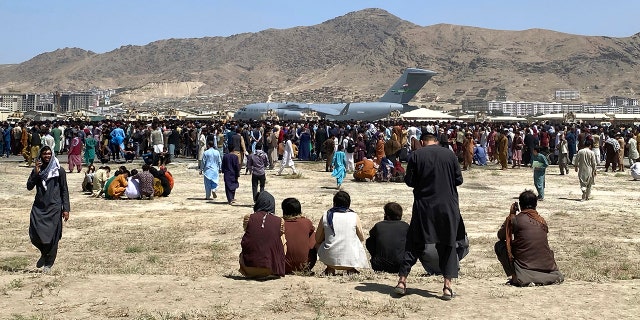 Hundreds of people gather near a U.S. Air Force C-17 transport plane at the perimeter of the international airport in Kabul, Afghanistan, Monday, Aug. 16, 2021. (Associated Press)