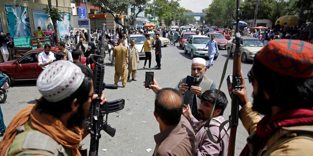 Afghans take selfie wit Taliban fighters during patrol in the city of Kabul, Afghanistan, Thursday, Aug. 19, 2021. The Taliban celebrated Afghanistan's Independence Day on Thursday by declaring they beat the United States, but challenges to their rule ranging from running a country severely short on cash and bureaucrats to potentially facing an armed opposition began to emerge. (AP Photo/Rahmat Gul)