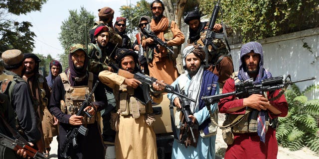Taliban fighters pose for a photograph in Kabul, Afghanistan, Thursday, Aug. 19, 2021. The Taliban celebrated Afghanistan's Independence Day on Thursday by declaring they beat the United States, but challenges to their rule ranging from running a country severely short on cash and bureaucrats to potentially facing an armed opposition began to emerge. (AP Photo/Rahmat Gul)