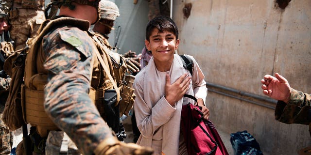 In this photo provided by the U.S. Marine Corps, a boy is processed through an Evacuee Control Checkpoint during an evacuation at Hamid Karzai International Airport, in Kabul, Afghanistan, Wednesday, Aug. 18, 2021. (Staff Sgt. Victor Mancilla/U.S. Marine Corps via AP)