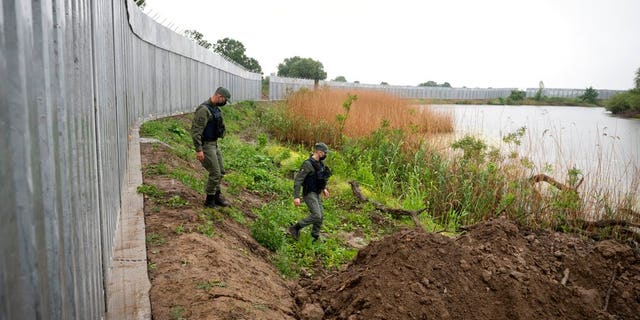 May 21, 2021: In this file photo, policemen patrol alongside a steel wall at Evros river, near the village of Poros, at the Greek -Turkish border, Greece.  (AP Photo/Giannis Papanikos, File)