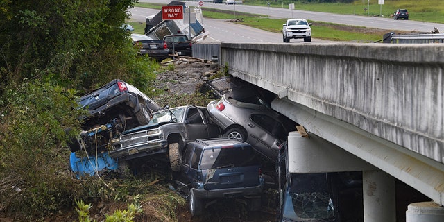 Cars are stacked on top of each other on the banks of Blue Creek being swept up in flood water, Monday, Aug. 23, 2021, in Waverly, Tennessee. (Associated Press)