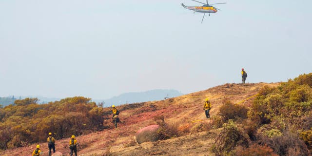 More than 13,500 firefighters were working to contain a dozen large California wildfires that have destroyed hundreds of homes and forced thousands of people to flee to safety.