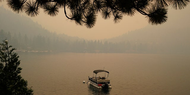 Smoke from the Caldor Fire, shrouds Fallen Leaf Lake near South Lake Tahoe, Calif., on Tuesday. The massive wildfire that is over a week old has scorched more than 190 square miles and destroyed hundreds of homes since Aug. 14. 