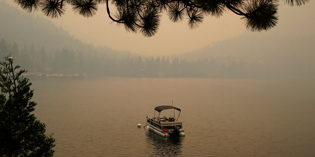 Smoke from the Caldor Fire, shrouds Fallen Leaf Lake near South Lake Tahoe, Calif., on Tuesday. The massive wildfire that is over a week old has scorched more than 190 square miles and destroyed hundreds of homes since Aug. 14.