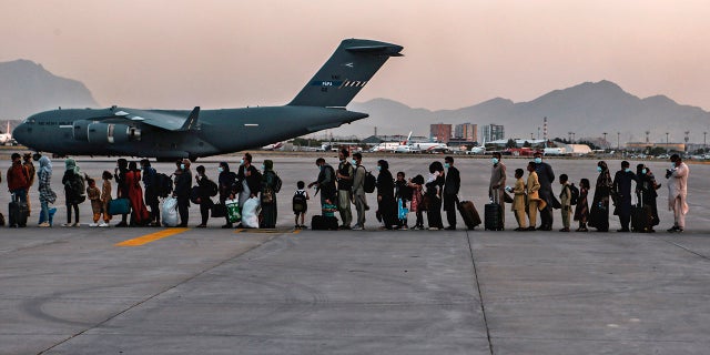 Evacuees wait to board a Boeing C-17 Globemaster III, at Hamid Karzai International Airport, Kabul, Afghanistan, Monday, Aug. 23, 2021.