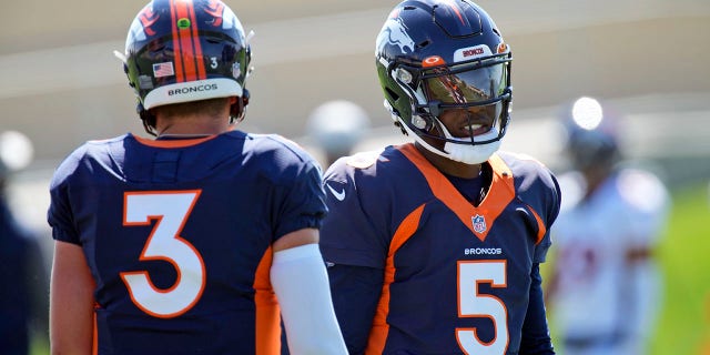 Denver Broncos quarterbacks Teddy Bridgewater, right, and Drew Lock take part in drills during NFL football practice at the team's headquarters Wednesday, Aug. 25, 2021, in Englewood, Colo.