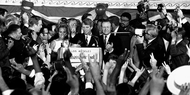 In this June 5, 1968, file photo, Sen. Robert F. Kennedy addresses campaign workers moments before being shot in Los Angeles. At his side are his wife, Ethel, and his California campaign manager, Jesse Unruh, speaker of the California Assembly. (AP Photo/Dick Strobel, File)