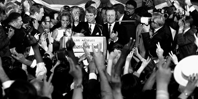 In this June 5, 1968, file photo, Sen. Robert F. Kennedy addresses campaign workers moments before being shot in Los Angeles. At his side are his wife, Ethel, and his California campaign manager, Jesse Unruh, speaker of the California Assembly. (AP Photo/Dick Strobel, File)