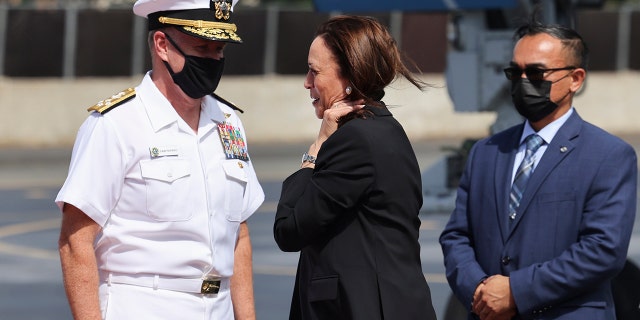 US Vice President Kamala Harris is greeted by Admiral Samuel Paparo, left, commander of the US Pacific Fleet, as she arrives at Joint Base Pearl Harbor-Hickam, Hawaii, prior to continue to Washington, Thursday, Aug. 26, 2021. (Evelyn Hockstein/Pool Photo via AP)
