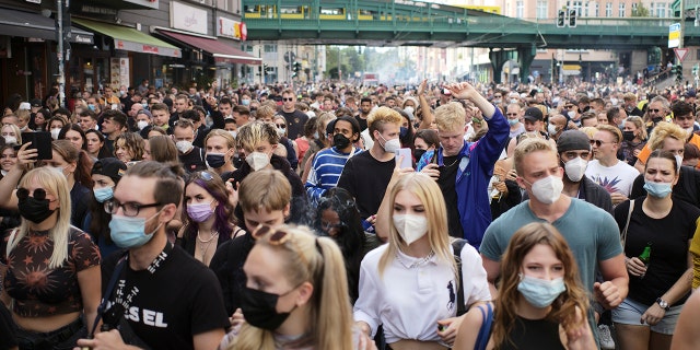 Menschen, die meist Masken tragen, tanzen hinter einem Lastwagen, während sie am Samstag, 28. August 2021, an einer Demonstration namens