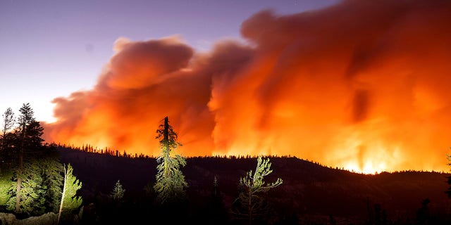 Seen in a long camera exposure, the Caldor Fire burns on Sunday, Aug. 29, 2021, in Eldorado National Forest, Calif. (AP Photo/Noah Berger)