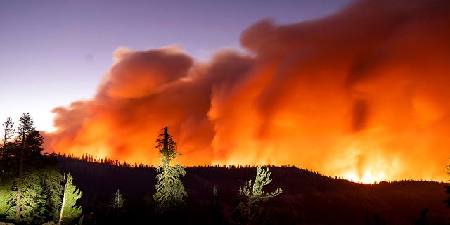 Seen in a long camera exposure, the Caldor Fire burns on Sunday, Aug. 29, 2021, in Eldorado National Forest, Calif. (AP Photo/Noah Berger)