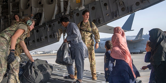 In this image provided by the U.S. Air Force, U.S. Air Force loadmasters and pilots assigned to the 816th Expeditionary Airlift Squadron, load people being evacuated from Afghanistan onto a U.S. Air Force C-17 Globemaster III at Hamid Karzai International Airport in Kabul, Afghanistan, Tuesday, Aug. 24, 2021.