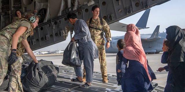 In this image provided by the U.S. Air Force, U.S. Air Force loadmasters and pilots assigned to the 816th Expeditionary Airlift Squadron, load people being evacuated from Afghanistan onto a U.S. Air Force C-17 Globemaster III at Hamid Karzai International Airport in Kabul, Afghanistan, Tuesday, Aug. 24, 2021.